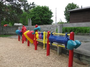 red, blue and yellow play drums in playground