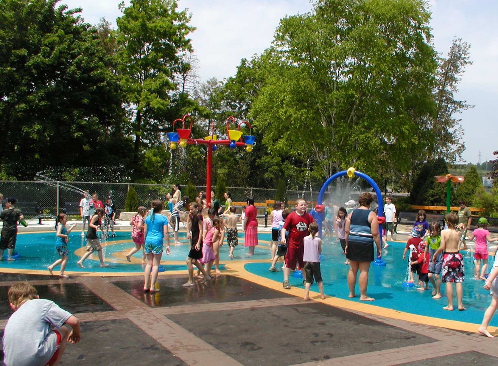 splash pad in summer with families playing