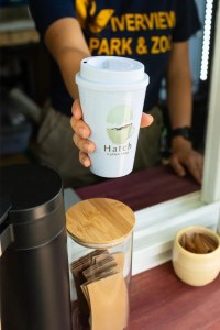 staff member presenting a cup of coffee