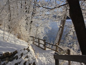 Walking trail with wooden fence covered in snow and ice on the trees