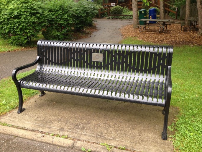 memorial bench on pathway with dedication plate