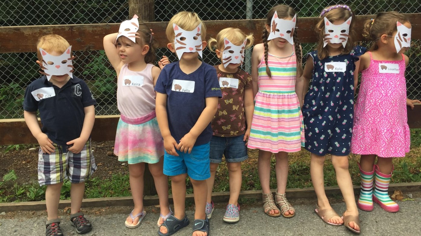Zoo crew members in monkey masks out on tour near exhibit fence