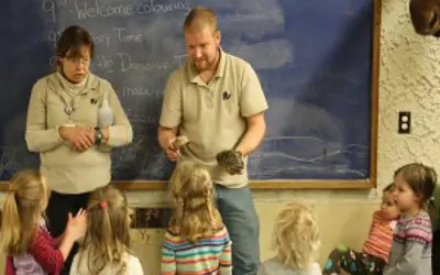 Two educator with turtles in front of classroom of young students
