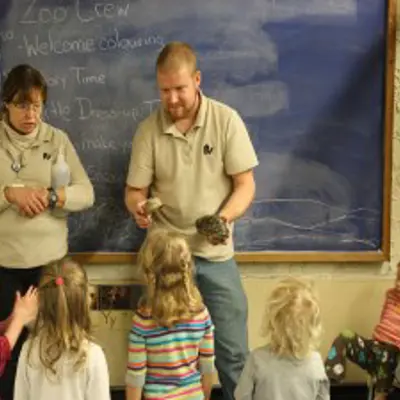 Two educator with turtles in front of classroom of young students