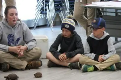 children listening to zoo staff talk about turtles