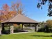 covered picnic shelter with picnic tables beneath and beside the river